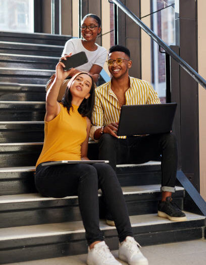 Shot of a group of young businesspeople taking selfies during a meeting on the stairs of a modern office