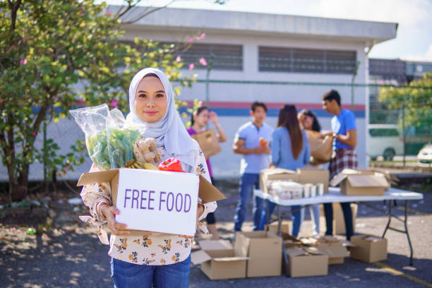 Portrait of Young woman in hijab holding the charity bag with great smile at public park.