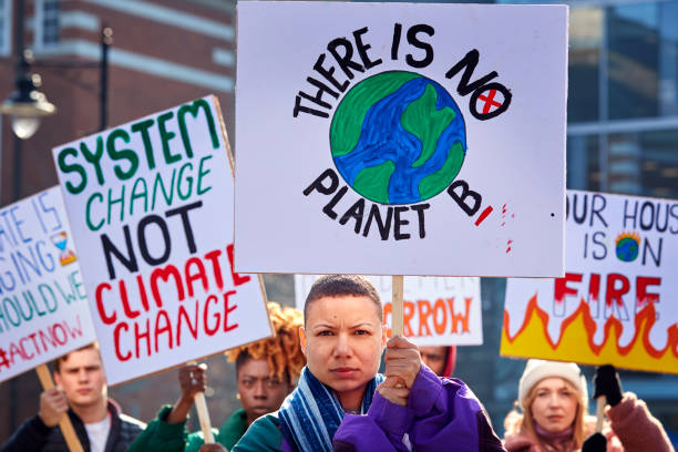 Group Of Protestors With Placards On Demonstration March Against Climate Chane