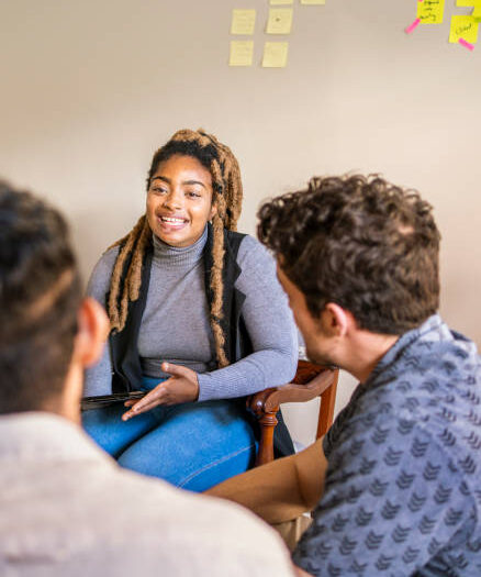 Smiling woman talking with colleagues during a meeting together in their startup's home office