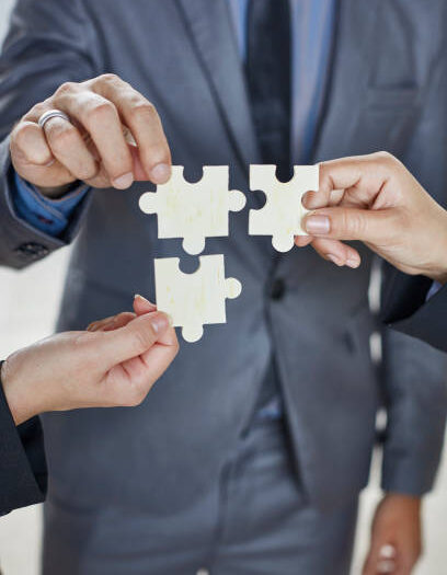 Cropped Image Of Business People Holding Jigsaw Puzzles At Office